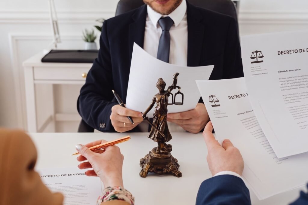 Personas revisan documentos legales alrededor de una figura de la justicia.